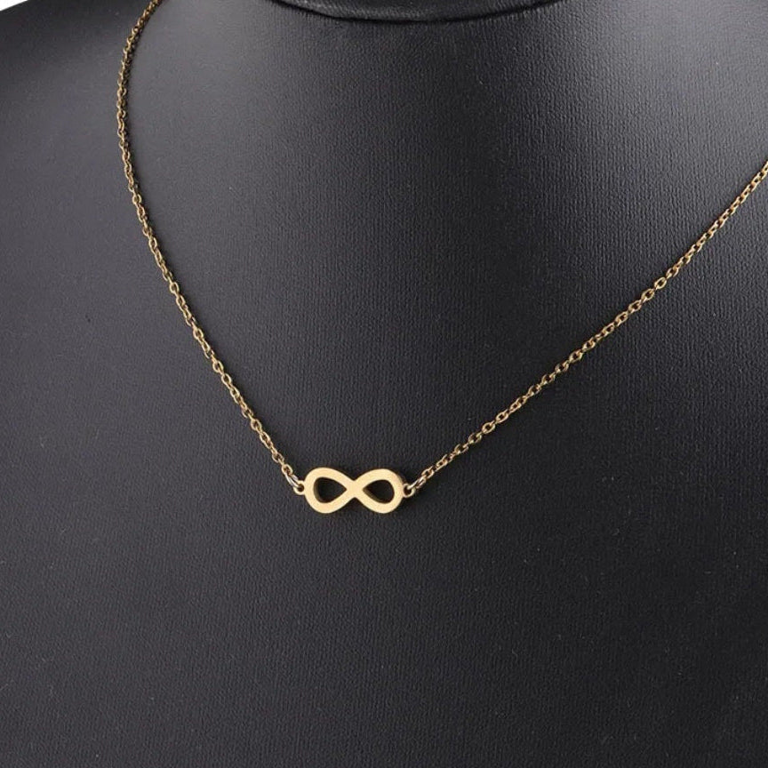 infinity necklace in gold and silver on a display mannequin, symbolizing eternity and love.