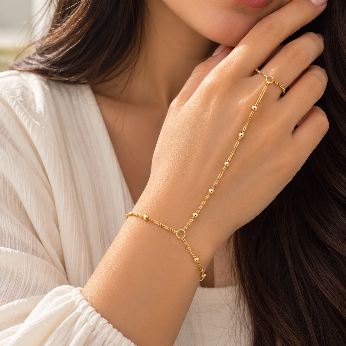 Gold beaded hand chain with finger loop, lobster clasp, and adjustable extension chain model hand