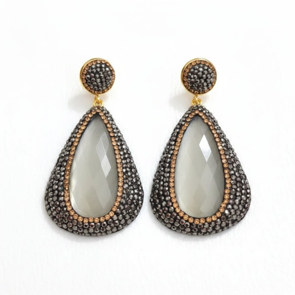 Cima stone pendant earrings featuring rhinestones with teardrop shape and gold plating, adding elegance to any outfit.