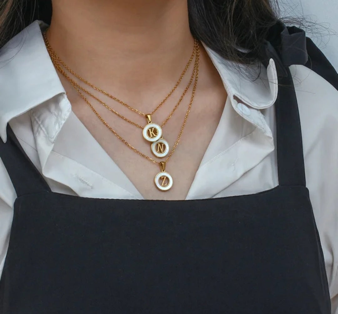 personalized initial necklace featuring K, N, Z pendants in gold plating, worn by a woman