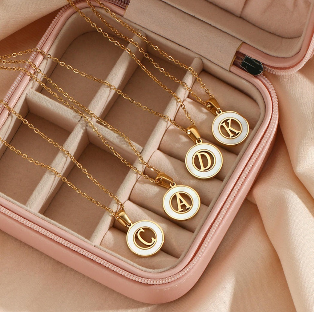 personalized initial necklace featuring gold pendants in an elegant jewelry case.