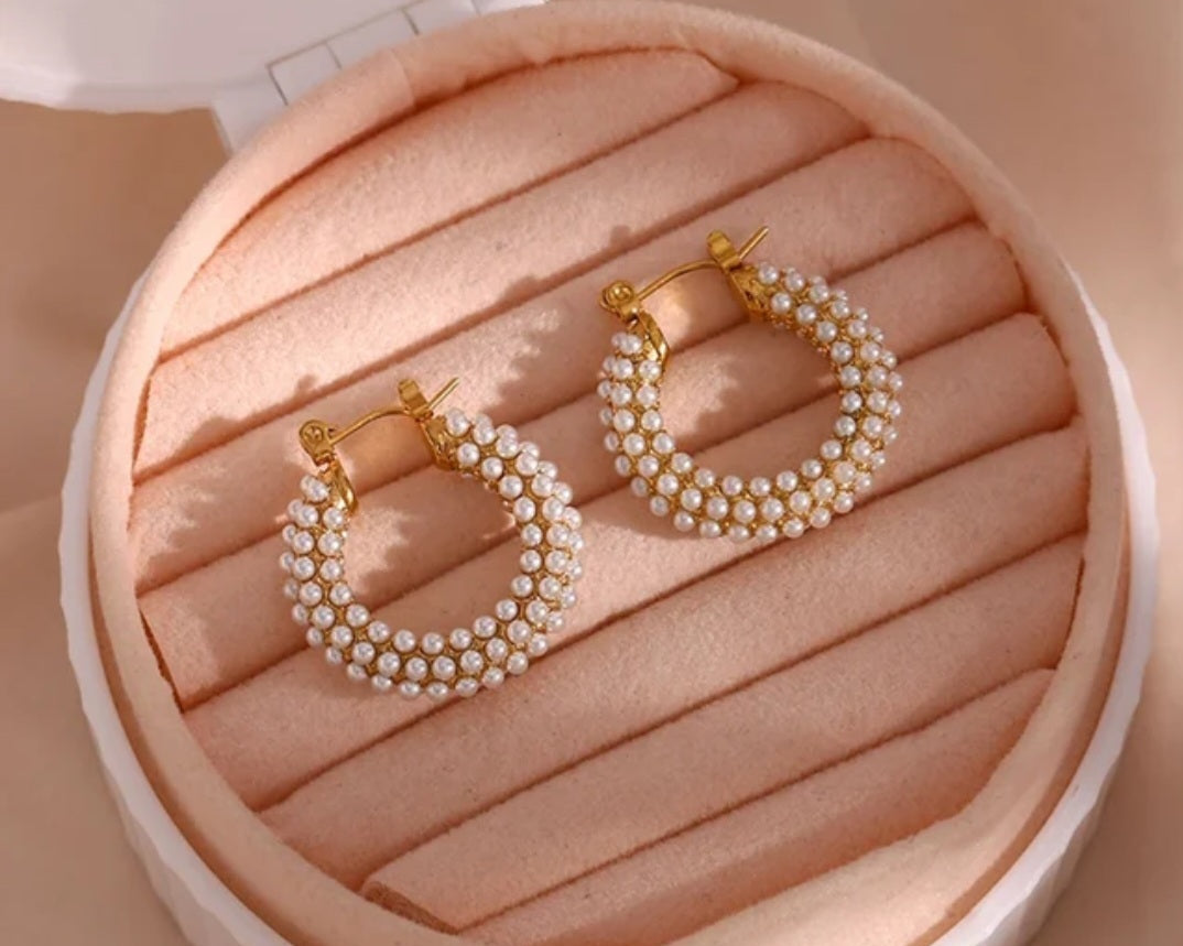 Chunky pearl hoop earrings beautifully displayed in a jewelry box with plush lining and secure closures.