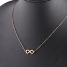 infinity necklace in gold and silver worn on a black background, symbolizing eternity and love.