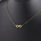 infinity necklace in gold and silver on a display mannequin, symbolizing eternity and love.