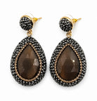 Nisa stone pendant earrings in bronze with rhinestone embellishments, featuring teardrop stone design.