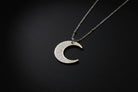 Ayatul Kursi necklace crescent with intricate designs on a silver crescent pendant.