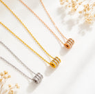Cubic zirconia pendant necklace collection featuring sleek cylindrical designs in silver, gold, and rose gold styles.